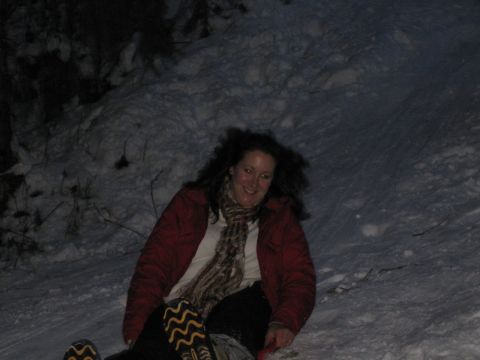 1990 Ford Bronco - A woman enjoys a nighttime sledding adventure down a snow-covered slope.