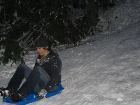 1990 Ford Bronco - A person enjoys a nighttime sledding adventure down a snowy slope.
