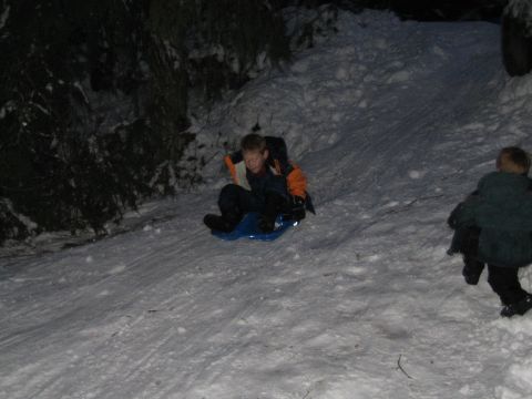 1990 Ford Bronco - Two children enjoy a nighttime sledding adventure down a snow-covered hill.