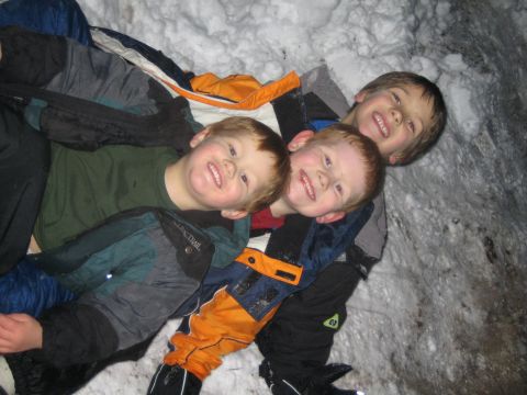 1990 Ford Bronco - Three young boys are happy to be playing together in the snow, dressed in winter clothing.