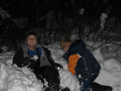 1990 Ford Bronco - Two children enjoy a snowy night, one looking towards the camera while the other is engrossed in playing.
