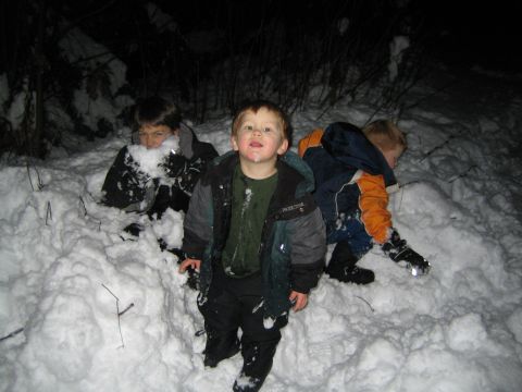 1990 Ford Bronco - Children are playing in the snow at night, with one child in the foreground looking at the camera.