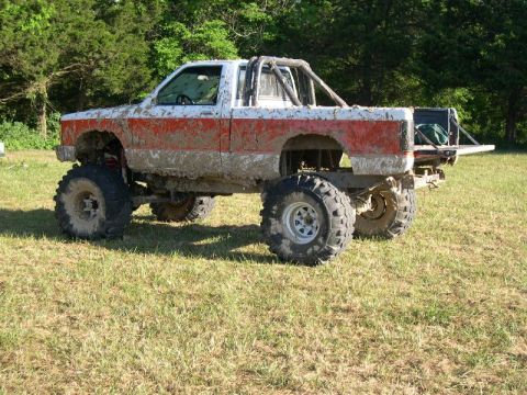1999 Jeep TJ - This heavily modified pickup truck appears to be used for off-roading, as evidenced by the mud coverage and large tires.