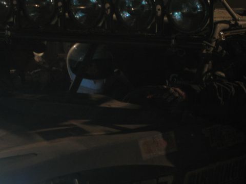 1990 Ford Bronco - dim close-up of an off-road vehicle's roof light bar fitted with skull-graphic auxiliary lamps at night.