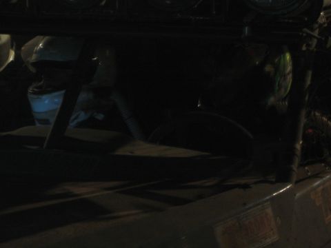 1990 Ford Bronco - very dark close-up showing the cluttered interior and roof light bar of an off-road vehicle at night.