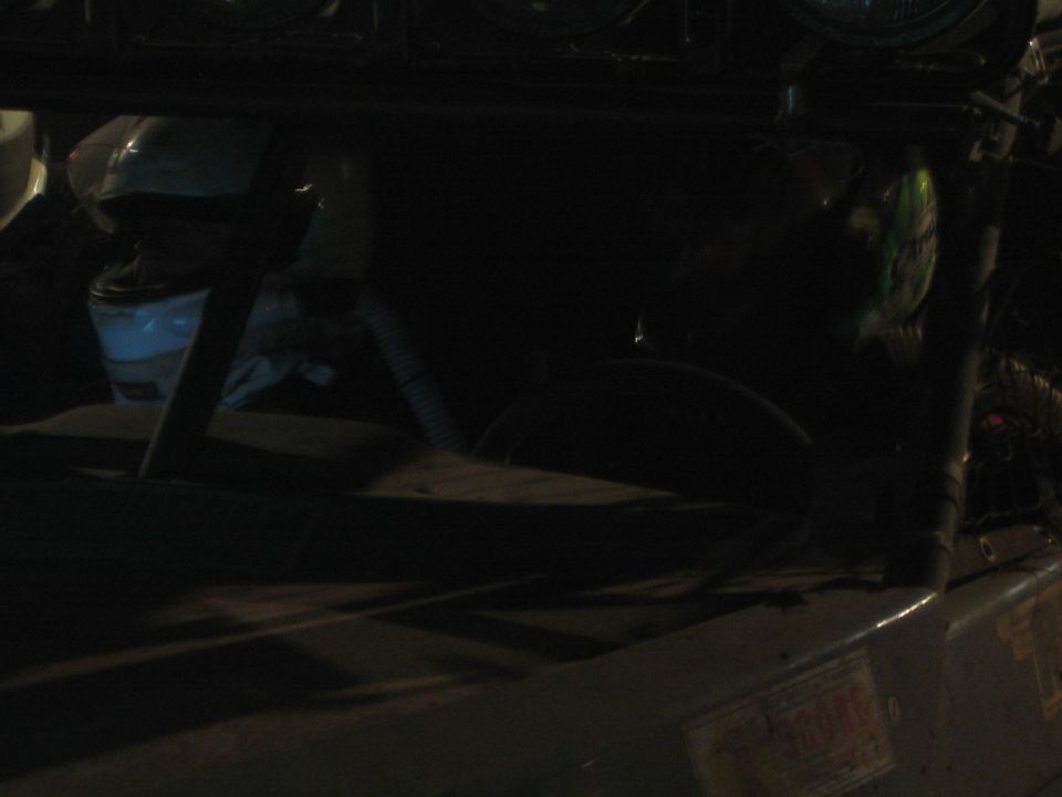 Very dark close-up of an off-road vehicle interior and light bar at night