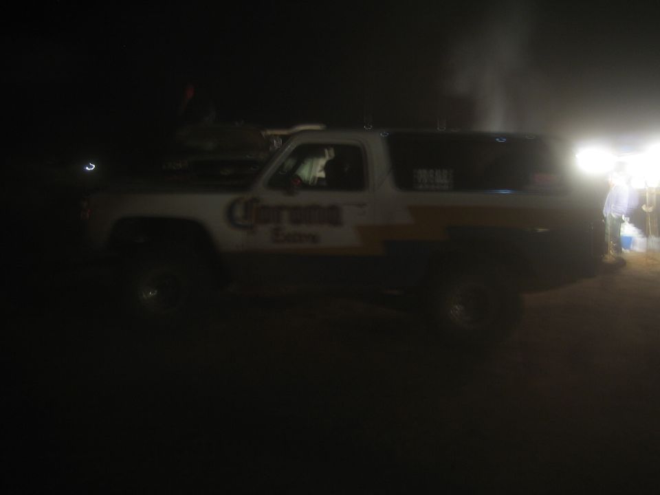 Lifted two-door SUV with Corona Extra livery in a dark dusty lot