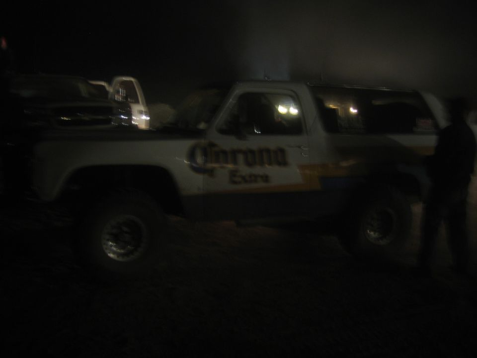 Lifted two-door Corona Extra SUV in profile at night with a person nearby