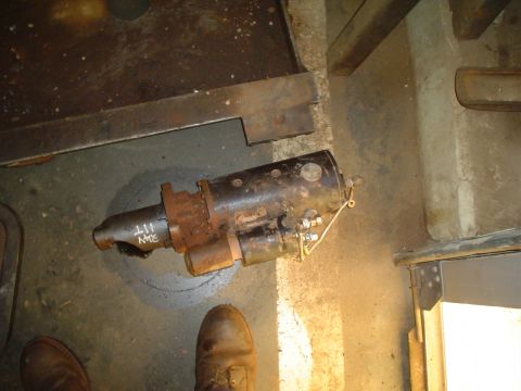 1966 International School Bus - A rusty starter motor is shown resting on a concrete floor, with some handwritten markings on its shaft.