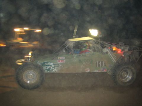 1990 Ford Bronco - green off-road race buggy numbered 1608 with flame graphics and BFGoodrich decals races at night.
