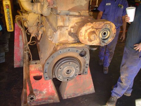 1966 International School Bus - Engine assembly on jack stands, with two mechanics observing the work.