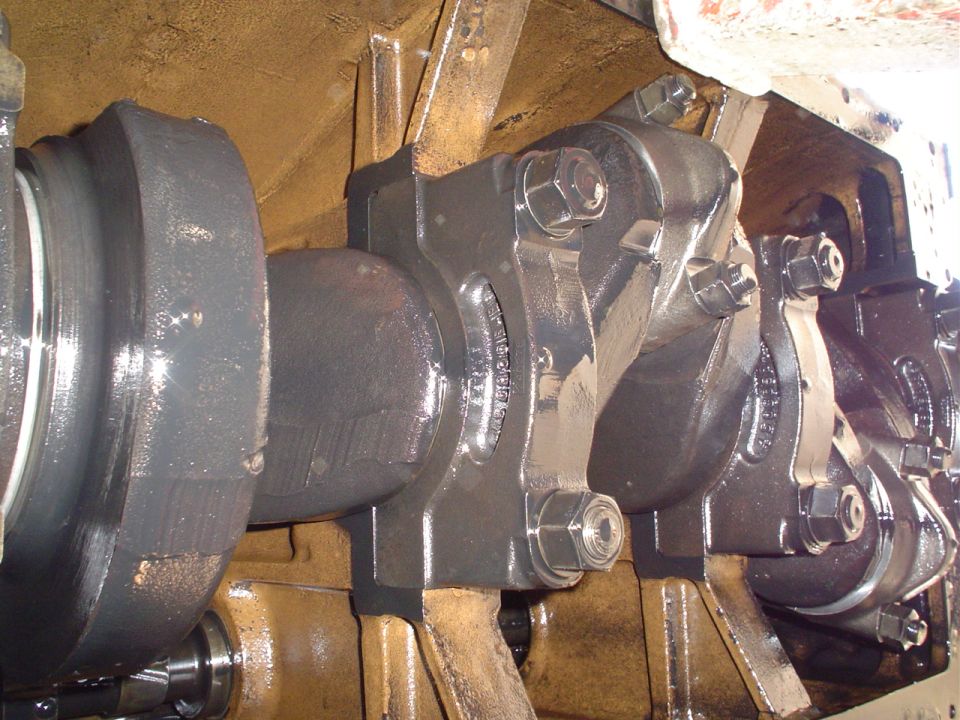 Engine crankshaft and main bearing caps inside an engine block