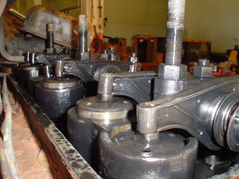 1966 International School Bus - Detailed view of the internal workings of an engine's valve train, showing rocker arms and valve stems covered in oil.