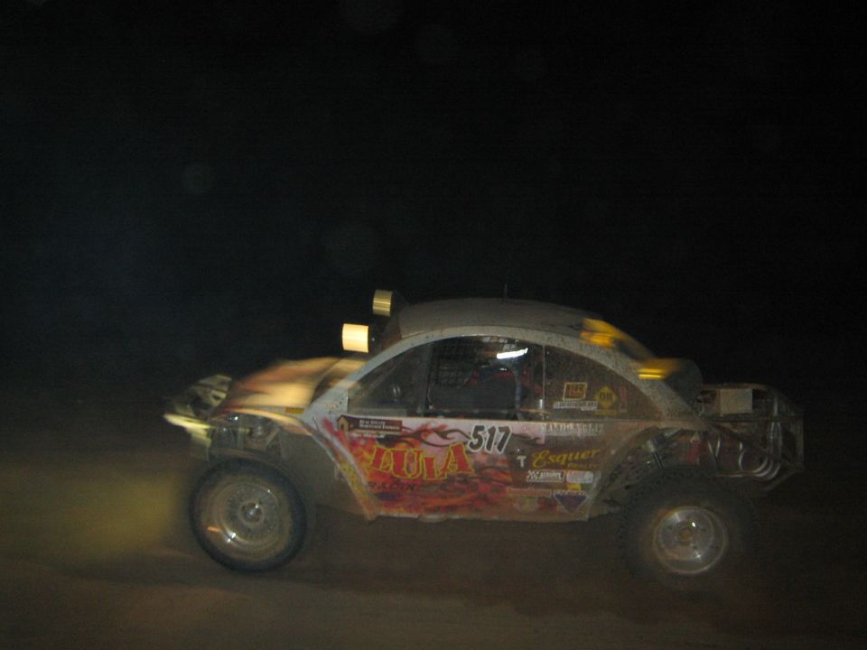 Beetle-bodied off-road racer number 517 with red graphics at night