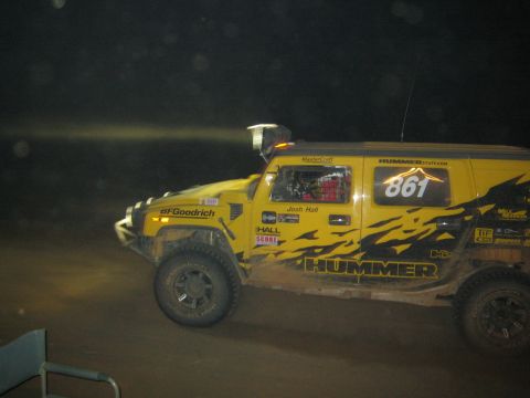 1990 Ford Bronco - yellow Hummer race vehicle numbered 861 and marked HUMMER and Josh Hall races across dirt at night.
