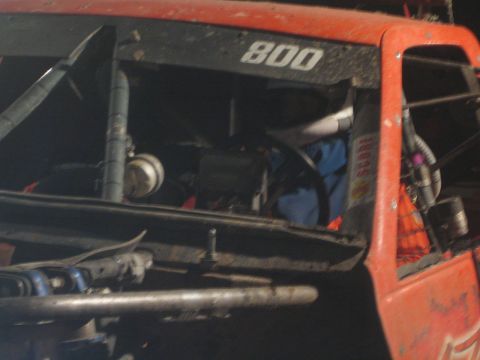 1990 Ford Bronco - close-up of the open engine and cab area of a red race truck stenciled 800, showing wiring, components and a Fox decal.