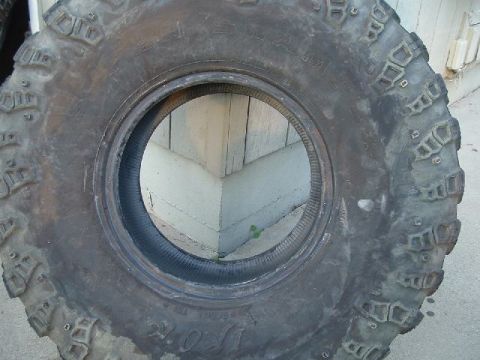 1989 Ford Bronco - A single, heavily treaded off-road tire is shown, with some text visible on its sidewall.