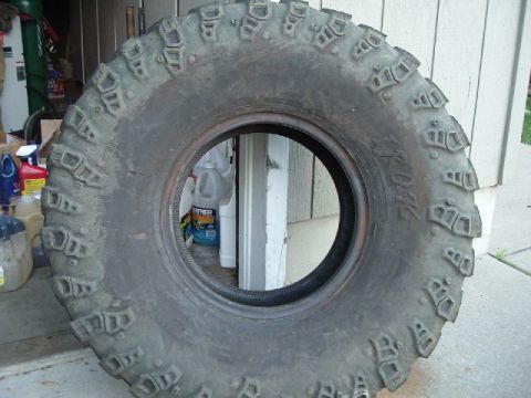 1989 Ford Bronco - A close-up view of a large tire, likely for off-road use, with visible tread details and some text on the sidewall.