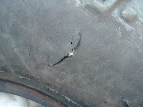 1989 Ford Bronco - Close-up of a damaged tire with visible text indicating 'ROAD RANGE'.