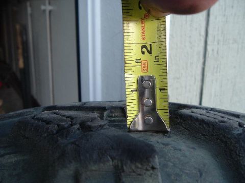 1989 Ford Bronco - Tire tread depth is being measured with a Stanley tape measure, indicating a measurement of approximately 2 inches.