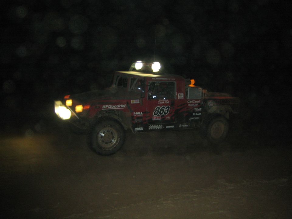 Red Hummer-type race vehicle number 863 driving at night