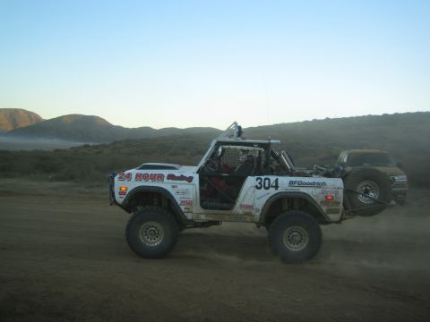 White early Ford Bronco race truck number 304 racing on dirt