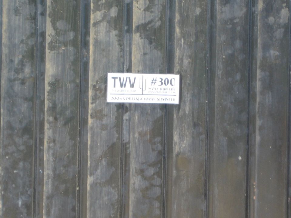 TWW #300 racing sticker on weathered metal siding