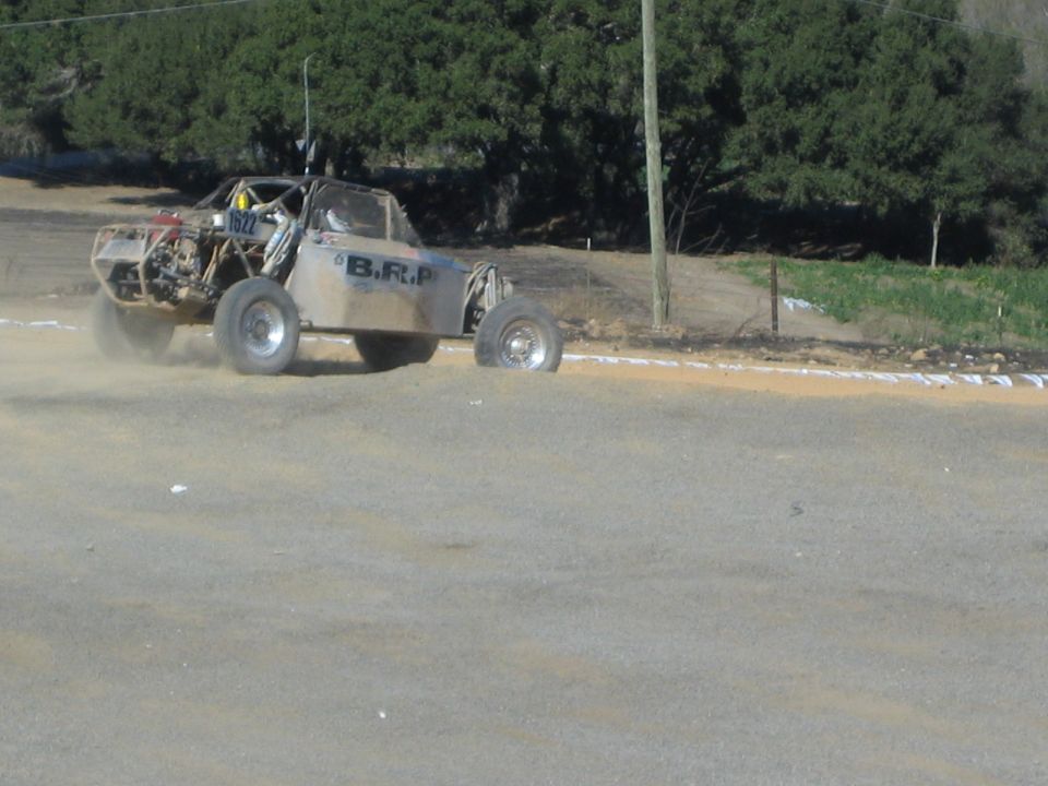 Single-seat off-road race buggy on a dirt track lettered B.R.P