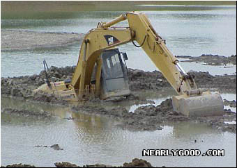 1989 Ford Bronco - An excavator is stuck in a muddy body of water, with only its cab and arm visible above the surface.