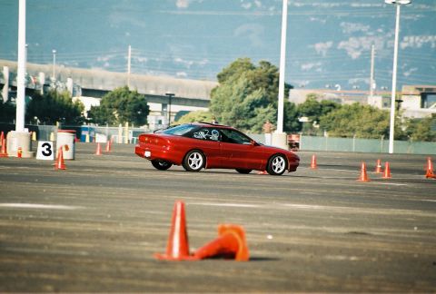 1997 Ford Probe - A red 1997 Ford Probe navigates a cone course during an auto-cross event.