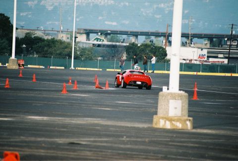 1997 Ford Probe - A red sports car navigates a course marked by orange cones on a paved lot.