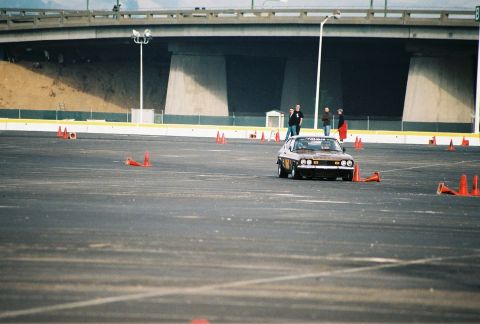 1997 Ford Probe - Sports car driving through an auto-cross course marked by orange cones.
