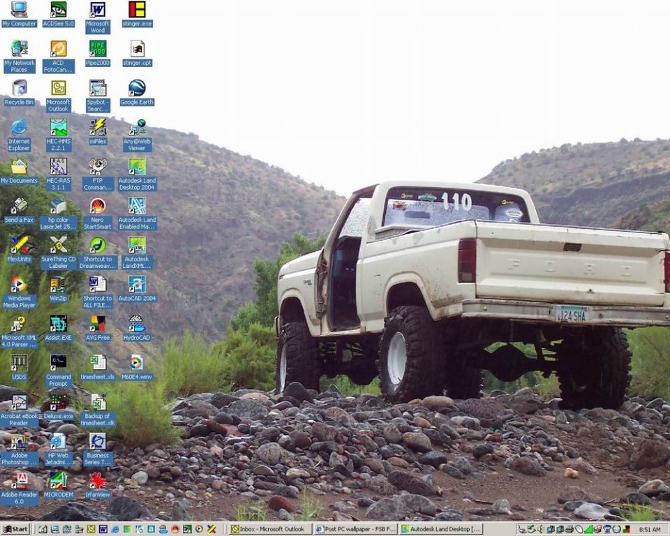White Ford pickup truck with lifted suspension and off-road tires, parked on a rocky terrain