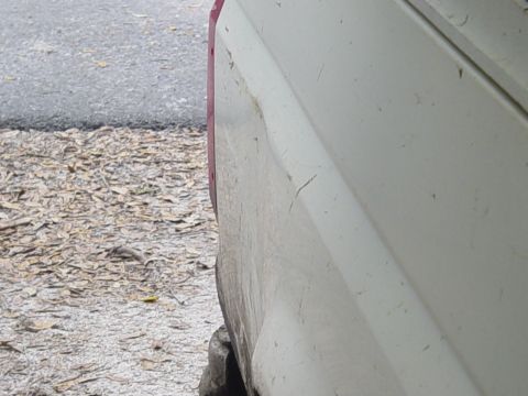 1989 Ford Bronco - The rear quarter panel of a white 1989 Ford Bronco shows some wear and tear.