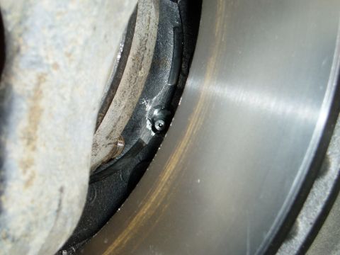 2000 Ford E350 - A close-up view of a brake caliper grease fitting on a vehicle's braking system.