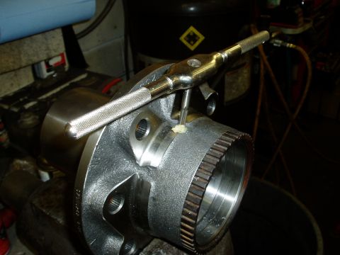2000 Ford E350 - A wheel hub is being threaded with a tap tool, likely for a repair or maintenance procedure.