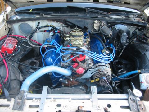 1985 Ford Crown Victoria LTD - Engine bay view of a V8 motor with aftermarket parts and visible Supermotors.net branding.