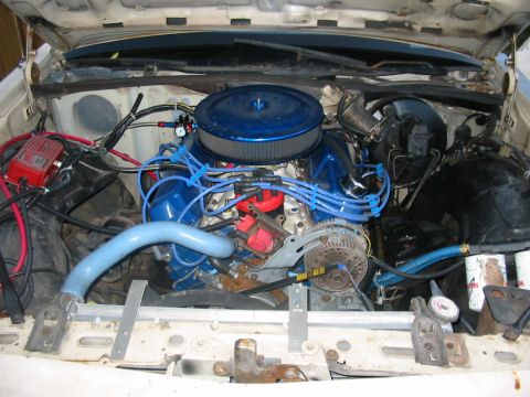 1985 Ford Crown Victoria LTD - Engine bay view showing a blue air filter and blue spark plug wires, with visible hoses and electrical components.