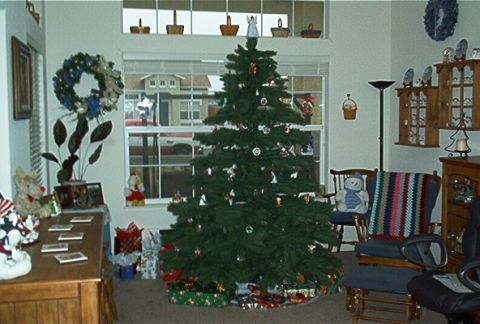 1986 Ford Bronco - A festive indoor scene a Christmas tree adorned with ornaments and surrounded by wrapped gifts.