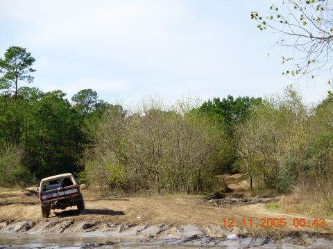 1987 Ford Bronco - 1987 Ford Bronco navigating a challenging muddy terrain during an off-road excursion.
