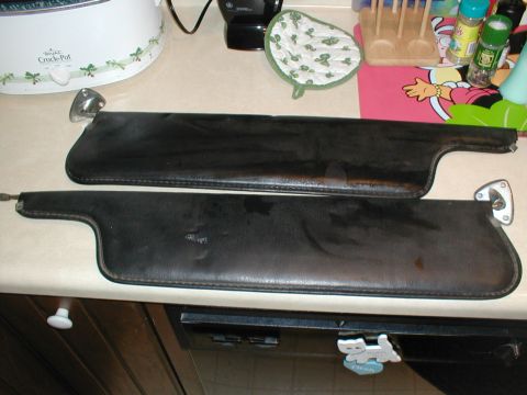 1979 Ford Bronco - Two black car sun visors are shown on a countertop, likely for sale or repair.