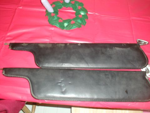 1979 Ford Bronco - A pair of used black sun visors are displayed on a red tablecloth, with a festive wreath overhead.