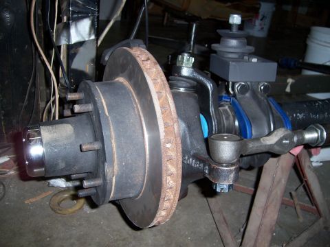 1983 Ford Bronco - Close-up of a Ford Bronco front axle assembly, showing brake rotor and steering components.