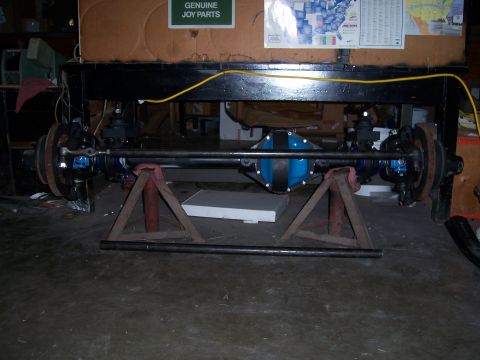 1983 Ford Bronco - Rear axle assembly on jack stands, with a blue differential cover visible.