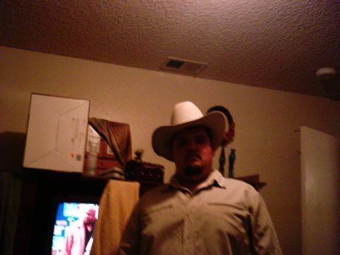 1986 Ford Bronco - A man wearing a cowboy hat is pictured indoors with a television and a box in the background.