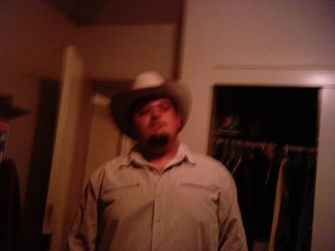 1986 Ford Bronco - A man wearing a cowboy hat poses for a photo indoors.