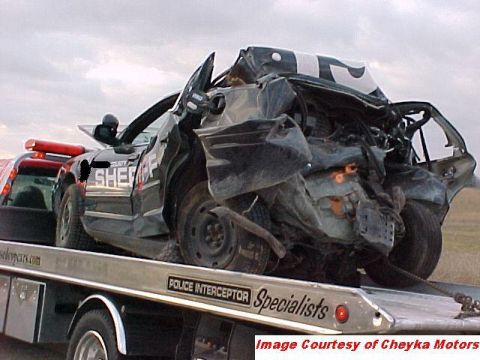 2000 Ford Crown Victoria - This heavily damaged sheriff's car is being towed, with visible 'SHERIFF' markings on the door.