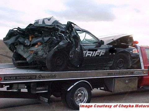 2000 Ford Crown Victoria - Heavily damaged 2000 Ford Crown Victoria police car being transported on a tow truck.