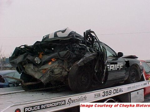 2000 Ford Crown Victoria - This heavily damaged 2000 Ford Crown Victoria, marked as a sheriff's vehicle, is being transported on a tow truck.