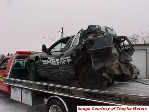 2000 Ford Crown Victoria - A severely damaged 2000 Ford Crown Victoria police car is being transported on a tow truck.